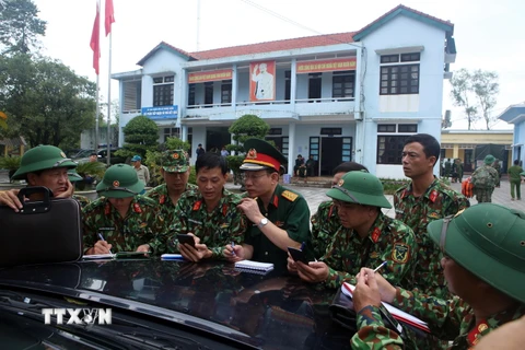 Các lực lượng họp bàn kế hoạch trước lúc lên đường tiến vào khu vực thủy điện Rào Trăng 3. (Ảnh: Trần Lê Lâm/TTXVN)
