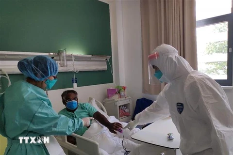 Nhân viên y tế điều trị cho bệnh nhân mắc COVID-19 tại bệnh viện ở Vientiane, Lào. (Ảnh: THX/TTXVN)