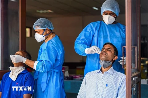 Nhân viên y tế lấy mẫu dịch xét nghiệm COVID-19 cho người dân tại New Delhi, Ấn Độ. (Ảnh: AFP/TTXVN)