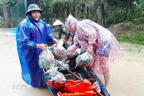 Lực lượng biên phòng Quảng Bình hỗ trợ nhân dân ứng phó mưa lũ, chuẩn bị lương thực thực phẩm giúp đỡ, đồng hành cùng nhân dân. (Ảnh: TTXVN phát)