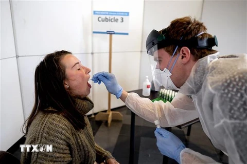 Nhân viên y tế lấy mẫu xét nghiệm COVID-19 tại Leuven, Bỉ. (Ảnh: AFP/TTXVN)