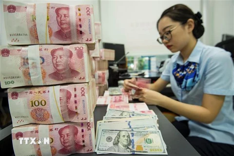 Kiểm đồng 100 nhân dân tệ tại ngân hàng ở tỉnh Giang Tô, Trung Quốc. (Ảnh: AFP/TTXVN)
