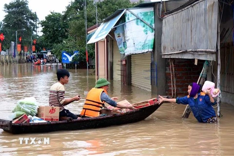 Lực lượng cứu trợ và các nhà hảo tâm vận chuyển hàng tới cho nhân dân vùng lũ. (Ảnh: Công Tường/TTXVN)