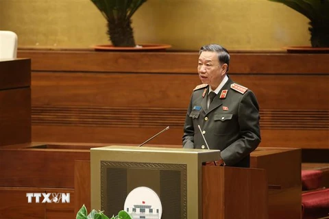 Bộ trưởng Bộ Công an Tô Lâm thừa ủy quyền của Thủ tướng Chính phủ trình bày Tờ trình về dự án Luật Lực lượng tham gia bảo vệ an ninh, trật tự ở cơ sở. (Ảnh: Dương Giang/TTXVN)