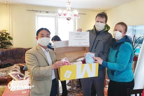 Ông Trịnh Tân (bên trái) trao tặng khẩu trang hỗ trợ chống dịch COVID-19 tại Ostrava. (Ảnh: Hồng Kỳ/Vietnam+)