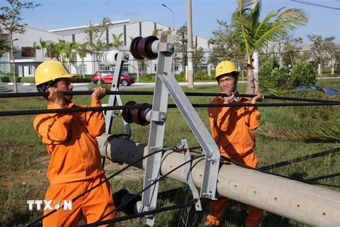Công nhân Công ty Điện lực Quảng Nam khắc phục sự cố điện do ảnh hưởng của bão số 9. (Ảnh: TTXVN phát)