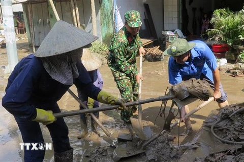 Lực lượng quân đội và đoàn thanh niên dọn dẹp vệ sinh tại thị trấn La Hai, huyện Đồng Xuân. (Ảnh: Xuân Triệu/TTXVN)