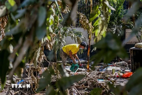 Người dân dọn đống đổ nát sau bão Vamco tại Manila, Philippines. (Ảnh: THX/TTXVN)