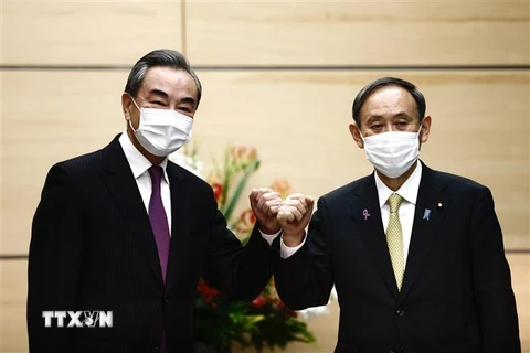 Thủ tướng Nhật Bản Suga Yoshihide (phải) và Bộ trưởng Ngoại giao Trung Quốc Vương Nghị (trái) tại cuộc gặp ở Tokyo, Nhật Bản. (Ảnh: AFP/TTXVN)