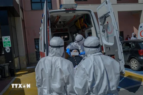 Nhân viên y tế chuyển bệnh nhân mắc COVID-19 từ xe cứu thương vào một bệnh viện ở Istanbul, Thổ Nhĩ Kỳ. (Ảnh: AFP/TTXVN)