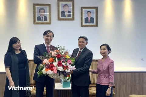 Đại sứ Nguyễn Tất Thành tặng hoa chúc mừng Đại sứ Lào Sisavath Inphachanh. (Ảnh: Nguyễn Minh/Vietnam+)