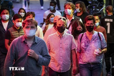 Người dân đeo khẩu trang phòng dịch COVID-19 tại Amsterdam, Hà Lan. (Ảnh: AFP/TTXVN)