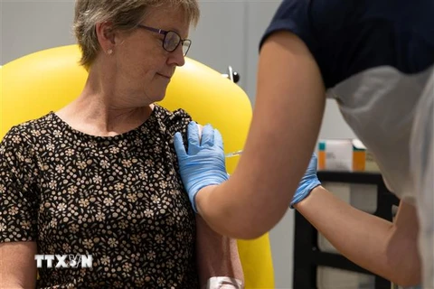 Nhân viên y tế tiêm thử nghiệm vắcxin ngừa COVID-19 cho người dân Anh. (Ảnh: AFP/TTXVN)