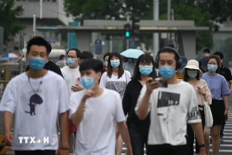 Người dân đeo khẩu trang phòng lây nhiễm COVID-19 tại Bắc Kinh, Trung Quốc. (Ảnh: AFP/TTXVN)