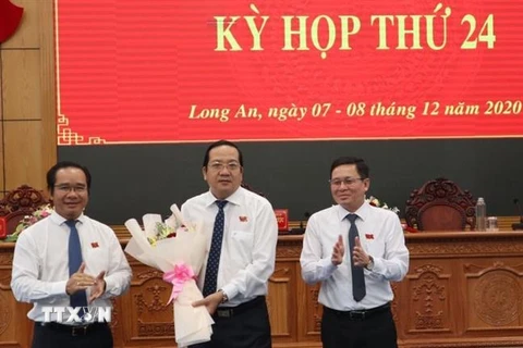 Bí thư Tỉnh ủy, Chủ tịch HĐND tỉnh Long An Nguyễn Văn Được (trái), tặng hoa chúc mừng Phó Chủ tịch UBND Nguyễn Minh Lâm. (Ảnh: Thanh Bình/TTXVN)