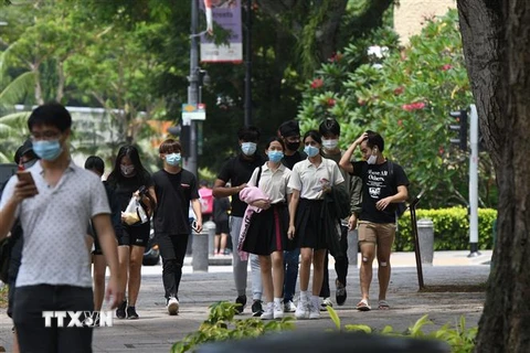 Người dân đeo khẩu trang phòng lây nhiễm COVID-19 tại Singapore. (Ảnh: THX/TTXVN)