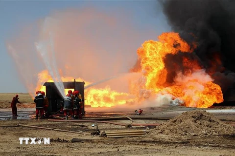 Nhân viên cứu hỏa Iraq nỗ lực khống chế đám cháy tại mỏ dầu Khabbaz sau vụ tấn công do các phần tử khủng bố IS tiến hành ngày 1/6/2016. (Ảnh: AFP/TTXVN)