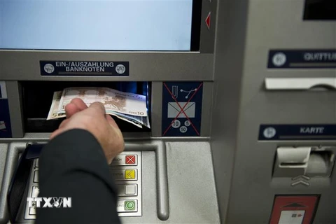 Người dân rút tiền tại cây rút tiền tự động (ATM) ở Berlin, Đức. (Ảnh: AFP/TTXVN)