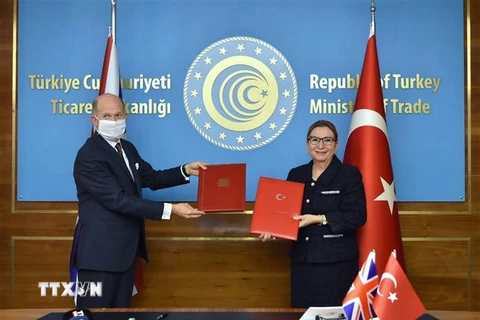 Bộ trưởng Thương mại Thổ Nhĩ Kỳ Ruhsar Pekcan (phải) và Đại sứ Anh tại Ankara Dominick Chilcott trao đổi văn kiện sau lễ ký thỏa thuận thương mại tự do Thổ Nhĩ Kỳ- Anh tại Ankara. (Ảnh: AA/TTXVN)