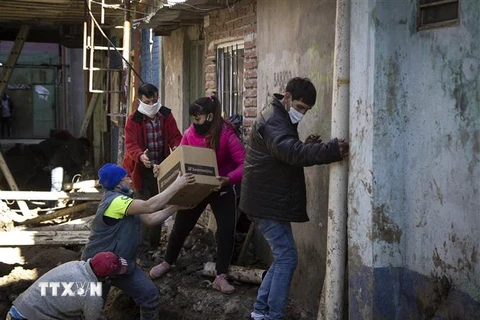 Tình nguyện viên phân phát lương thực cứu trợ do dịch COVID-19 cho người dân tại Buenos Aires, Argentina. (Ảnh: AFP/TTXVN)