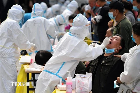 Nhân viên y tế lấy mẫu xét nghiệm COVID-19 cho người dân tại tỉnh Sơn Đông, Trung Quốc. (Ảnh: AFP/TTXVN)