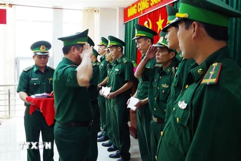 Đại tá Bùi Văn Vũ, Phó Chính ủy Bộ đội Biên phòng tỉnh Tiền Giang, trao quyết định điều động các cán bộ, chiến sỹ. (Ảnh: Hữu Chí/TTXVN)