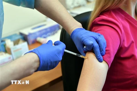 Nhân viên y tế tiêm vắcxin phòng COVID-19 của Pfizer cho người dân. (Ảnh: PAP/TTXVN)