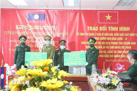 Bộ Chỉ huy Bộ đội Biên phòng tỉnh Quảng Bình trao tặng các thiết bị phòng, chống COVID-19 cho Bộ Chỉ huy Quân sự, Công an tỉnh Khammouan (Lào). (Ảnh: Đức Thọ/TTXVN)