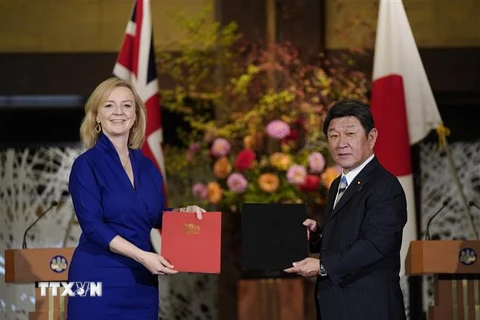 Ngoại trưởng Nhật Bản Toshimitsu Motegi (phải) và Bộ trưởng Thương mại quốc tế Anh Liz Truss (trái) trao đổi văn kiện sau khi ký thỏa thuận thương mại tự do song phương hậu Brexit, tại Tokyo ngày 23/10/2020. (Ảnh: AFP/TTXVN)
