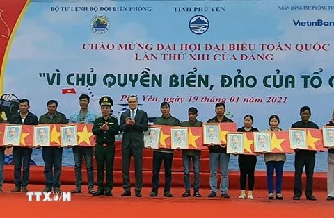 Trung tướng Đỗ Danh Vượng và Bí thư Tỉnh ủy Phú Yên Phạm Đại Dương trao cờ Tổ quốc cho ngư dân. (Ảnh: Xuân Triệu/TTXVN)