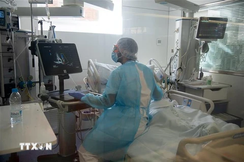 Nhân viên y tế điều trị cho bệnh nhân COVID-19 tại bệnh viện ở Barcelona, Tây Ban Nha. (Ảnh: THX/TTXVN)