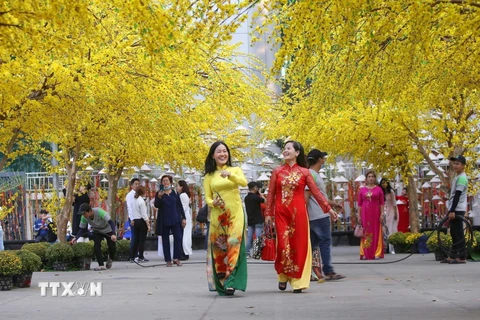 Khi đến với những điểm bán, phiên chợ Tết trên địa bàn Thành phố Hồ Chí Minh, người dân còn có thể chụp ảnh lưu lại không khí Xuân rực rỡ. (Ảnh: TTXVN)