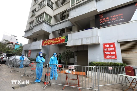 Lực lượng chức năng lập rào chắn, cách ly tòa nhà N03 Lạc Trung đảm bảo công tác phòng chống dịch. (Ảnh: Thành Đạt/TTXVN)