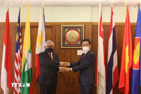 Đại sứ Việt Nam Hoàng Văn Lợi (phải) bàn giao vai trò Chủ tịch Ủy ban ASEAN tại Pretoria (APC) 2021 cho Đại sứ Indonesia Salman Al Farisi (trái). (Ảnh: Đình Lượng/TTXVN)