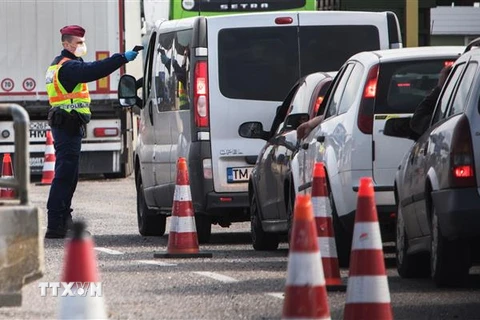 Cảnh sát kiểm tra thân nhiệt của người dân nhằm ngăn dịch COVID-19 lây lan, tại cửa khẩu Nickelsdorf/Hegyeshalom, biên giới Áo-Hungary. (Ảnh: AFP/TTXVN)