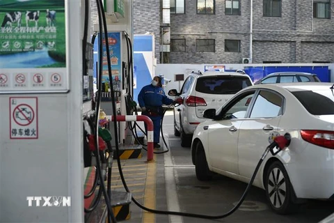 Bơm xăng cho các phương tiện tại trạm xăng ở tỉnh Giang Tô, Trung Quốc. (Ảnh: THX/TTXVN)