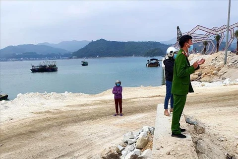 Lực lượng chức năng tại hiện trường khu vực nơi doanh nghiệp đổ trộm đất đá xuống vịnh Bái Tử Long. (Ảnh: TTXVN phát)