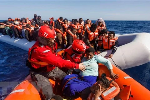 Các thành viên tổ chức cứu trợ Tây Ban Nha giải cứu người di cư trôi dạt ngoài khơi bờ biển Libya. (Ảnh: AFP/TTXVN)