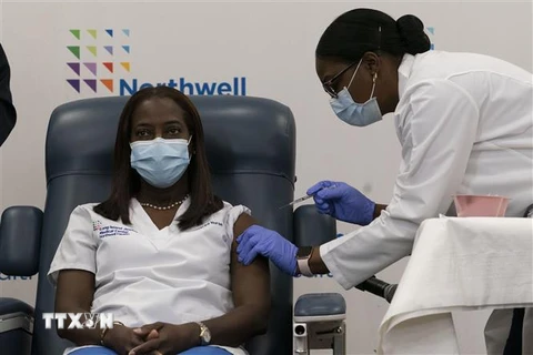 Nữ y tá Sandra Lindsay (trái) được tiêm mũi vaccine phòng COVID-19 đầu tiên của hãng Pfizer/BioNTech tại New York, Mỹ ngày 14/12/2020. (Ảnh: AFP/TTXVN)