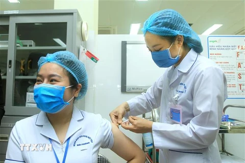 Điều dưỡng viên khu cách ly Bệnh viện Việt Tiệp cơ sở 2 Bùi Thị Thanh Nhung, sinh năm 1987, được tiêm mũi liều vaccine ngừa COVID-19 đầu tiên tại Hải Phòng. (Ảnh: An Đăng/TTXVN)