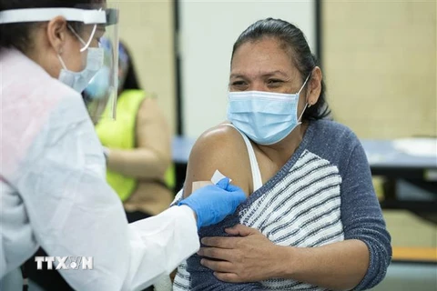 Nhân viên y tế Mỹ tiêm vaccine phòng COVID-19 cho người dân. (Ảnh: AFP/TTXVN)