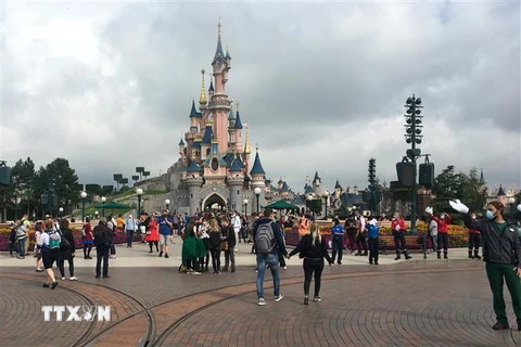 Du khách đeo khẩu trang khi tới thăm công viên Disneyland ở thủ đô Paris ngày 15/7/2020. (Ảnh: AFP/TTXVN)