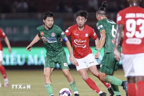 Pha tranh bóng giữa các cầu thủ đội Thành phố Hồ Chí Minh (áo đỏ) và đội Sài Gòn FC. (Ảnh: Thanh Vũ/TTXVN)