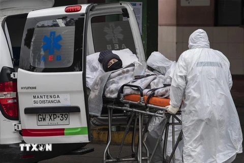 Nhân viên y tế chuyển bệnh nhân COVID-19 tới bệnh viện tại Santiago, Chile. (Ảnh: AFP/TTXVN)