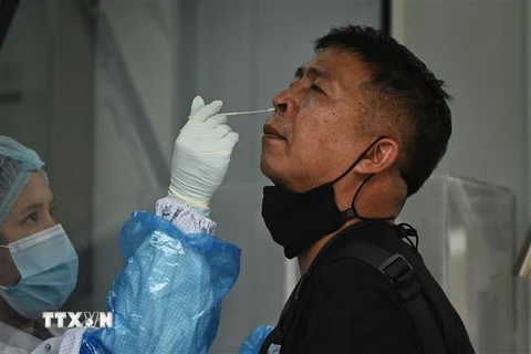 Nhân viên y tế lấy mẫu xét nghiệm COVID-19 cho người dân tại Bangkok, Thái Lan. (Ảnh: AFP/TTXVN)
