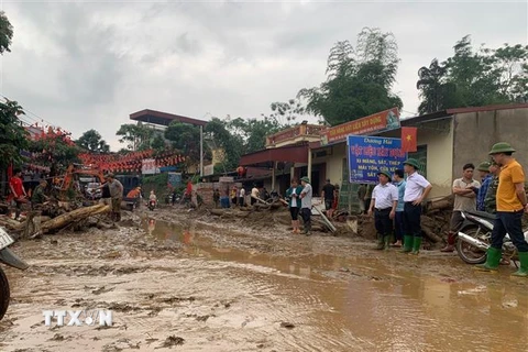 Bùn đất theo lũ trôi về tràn ngập trên Quốc lộ 279. (Ảnh Hồng Ninh/TTXVN)