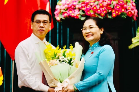 Chủ tịch Hội đồng Nhân dân Thành phố Hồ Chí Minh Nguyễn Thị Lệ tặng hoa chúc mừng ông Nguyễn Văn Dũng. (Nguồn: hcmcpv.org.vn)