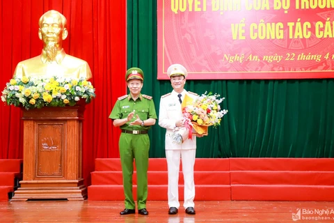 Thứ trưởng Bộ Công an Lê Quý Vương trao Quyết định và tặng hoa chúc mừng Đại tá Phạm Thế Tùng. (Nguồn: Báo Nghệ An)