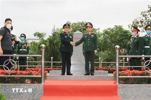 Bộ trưởng Quốc phòng Phan Văn Giang và Bộ trưởng Quốc phòng Trung Quốc Ngụy Phượng Hòa bắt tay nhau trước cột mốc chủ quyền 1317 (2) thuộc địa bàn xã Hoành Mô, huyện Bình Liêu, tỉnh Quảng Ninh. (Ảnh: Trọng Đức/TTXVN)