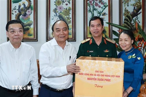 Chủ tịch nước Nguyễn Xuân Phúc đến thăm và tặng quà Thiếu tướng Hoàng Trung Kiên. (Ảnh: Thống Nhất/TTXVN)